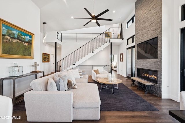 2296 E Haystacker Dr, Eagle, CO 81631 - living room with a fireplace, a ceiling fan, stairs, a towering ceiling, and dark wood-style flooring
