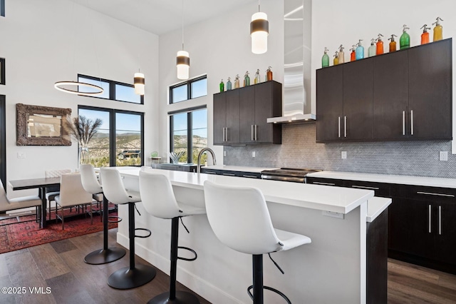 2296 E Haystacker Dr, Eagle, CO 81631 - kitchen with a breakfast bar area, light countertops, decorative backsplash, dark wood-style flooring, and a towering ceiling
