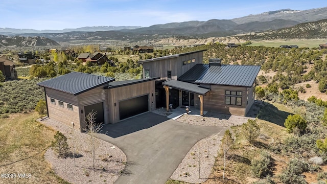 2296 E Haystacker Dr, Eagle, CO 81631 - view of front of house with an attached garage, a mountain view, driveway, and metal roof