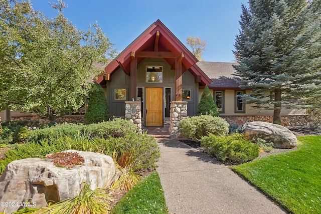 view of front of house with stone siding and a shingled roof