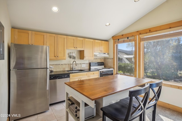 kitchen featuring lofted ceiling, under cabinet range hood, stainless steel appliances, a sink, and light brown cabinetry