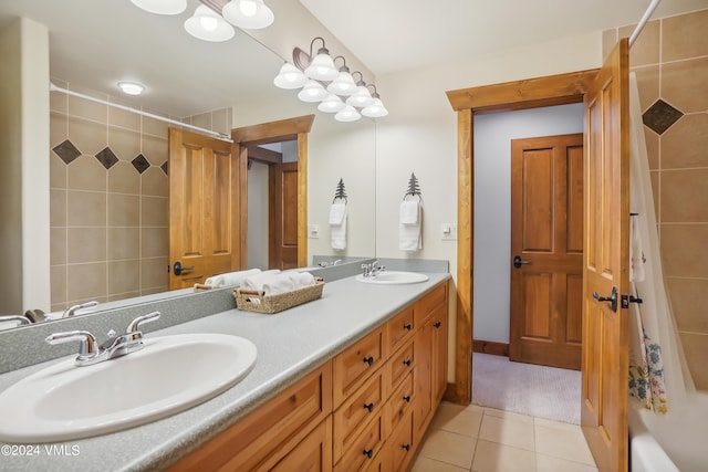 bathroom with double vanity, tile patterned flooring, a sink, and washtub / shower combination