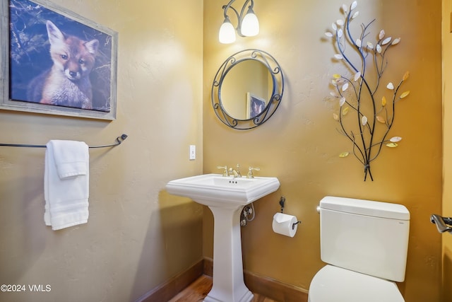 bathroom featuring a sink, toilet, and baseboards