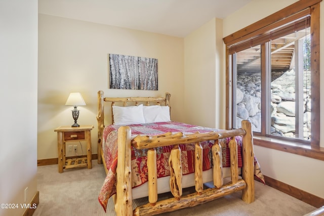 bedroom with baseboards and light colored carpet