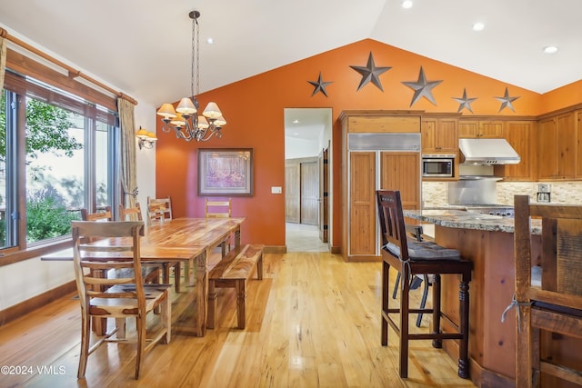 dining room featuring lofted ceiling, light wood finished floors, baseboards, and an inviting chandelier