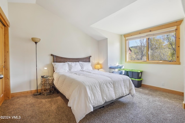 carpeted bedroom featuring lofted ceiling and baseboards