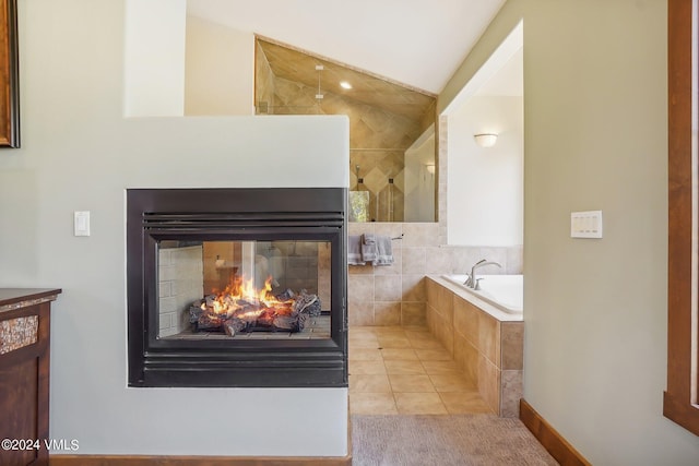 full bathroom with tile patterned flooring, a multi sided fireplace, vanity, vaulted ceiling, and a bath