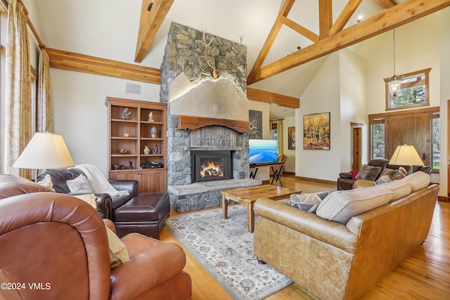 living room featuring high vaulted ceiling, a fireplace, visible vents, beam ceiling, and light wood finished floors