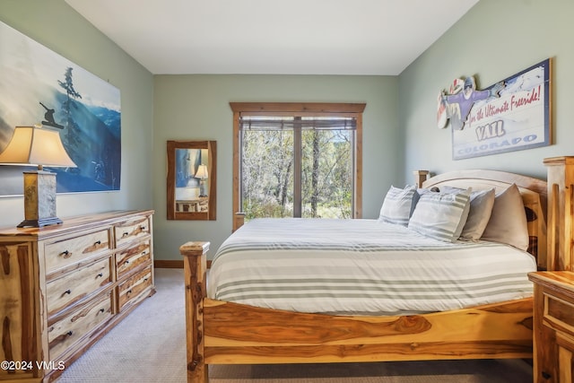 bedroom featuring light carpet and baseboards