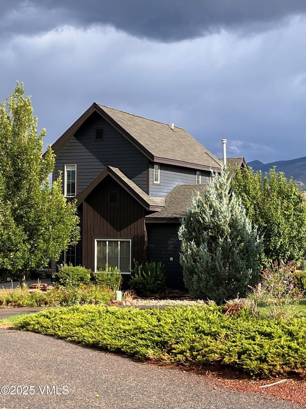 view of front of house featuring a mountain view and roof with shingles