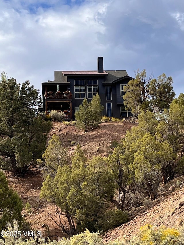 rear view of property with a wooden deck and a chimney