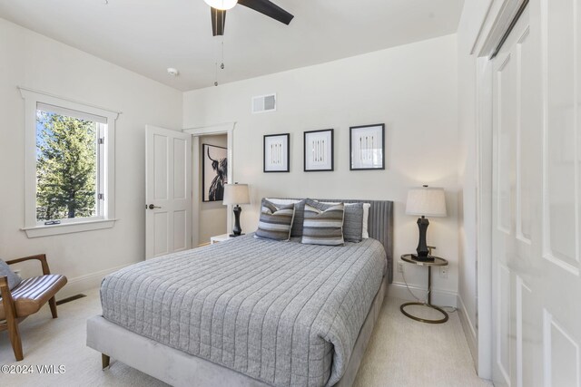 bedroom featuring light colored carpet and ceiling fan