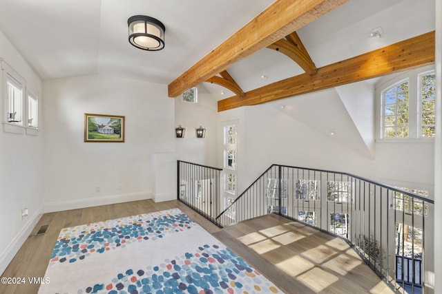 interior space featuring wood-type flooring, high vaulted ceiling, and beamed ceiling