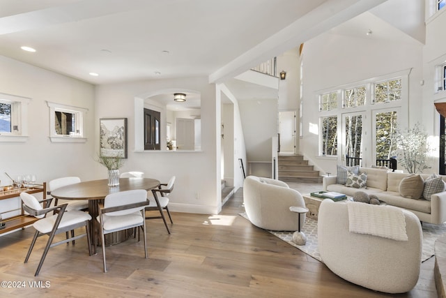 living room featuring a towering ceiling and light wood-type flooring