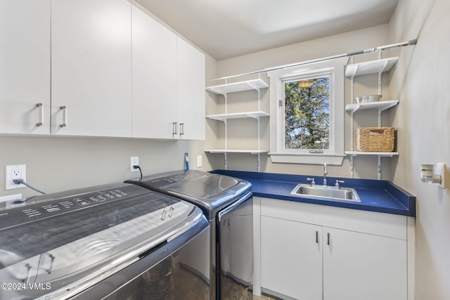 laundry room featuring sink, washing machine and dryer, and cabinets