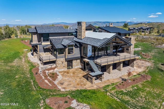 back of house with a mountain view and a patio