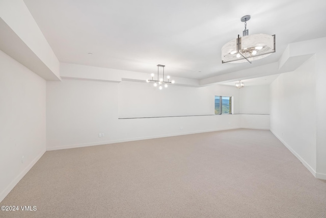 carpeted spare room with a chandelier