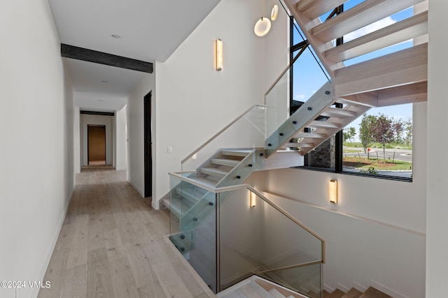 staircase featuring hardwood / wood-style flooring and a high ceiling