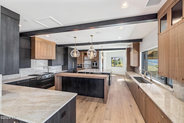 kitchen with a spacious island, beamed ceiling, sink, and pendant lighting