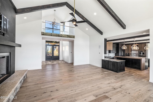 kitchen with beamed ceiling, a kitchen island, a fireplace, and light hardwood / wood-style floors