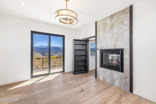 interior space featuring a mountain view, light hardwood / wood-style flooring, and a multi sided fireplace