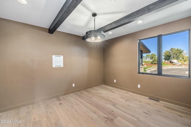 empty room with light wood-type flooring and beam ceiling