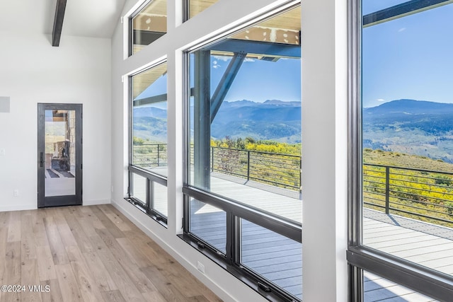 entryway featuring beam ceiling, a mountain view, and light hardwood / wood-style floors