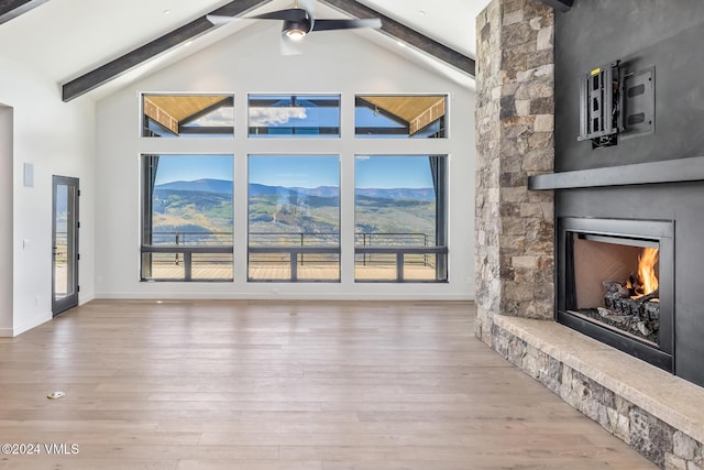 living room with a mountain view, hardwood / wood-style flooring, high vaulted ceiling, and beamed ceiling