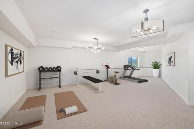 exercise room with carpet and a chandelier