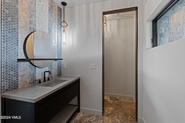 966 Webb Peak, Edwards, CO 81632 - bathroom featuring stone tile floors, baseboards, tasteful backsplash, and vanity