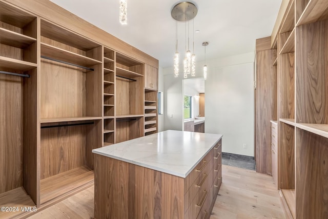 walk in closet with light hardwood / wood-style flooring