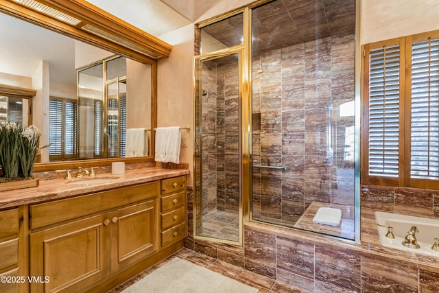 full bath with a stall shower, vanity, and a garden tub