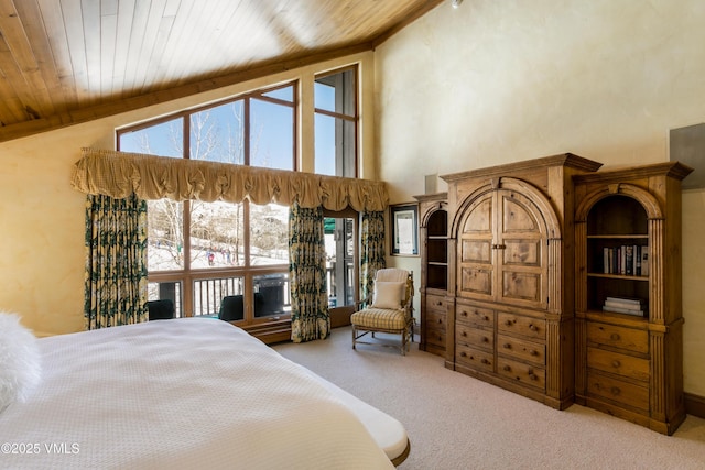 carpeted bedroom with high vaulted ceiling and wooden ceiling