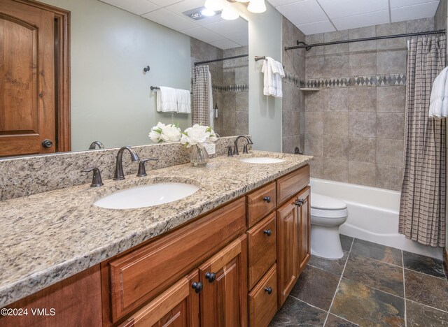 full bathroom featuring vanity, shower / tub combo, and toilet