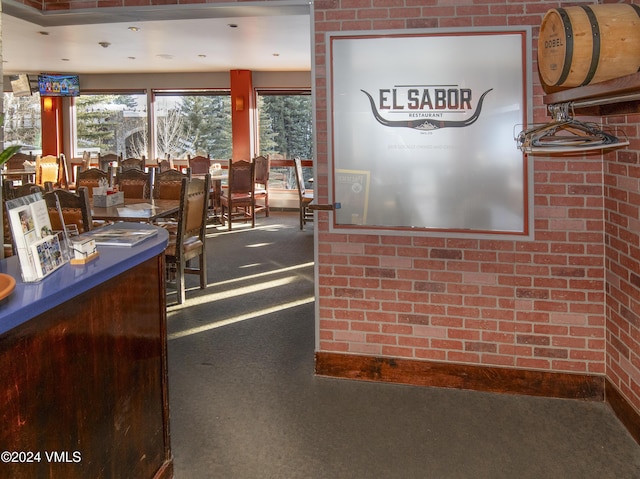 dining room featuring brick wall