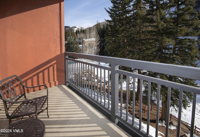 snow covered back of property featuring a mountain view