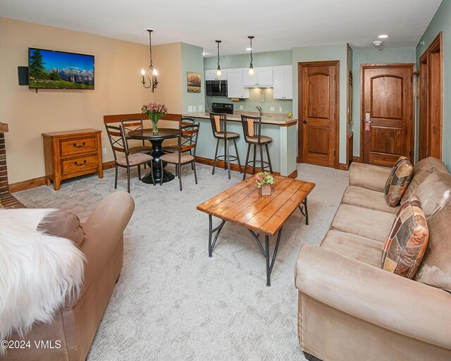 carpeted living room with a notable chandelier