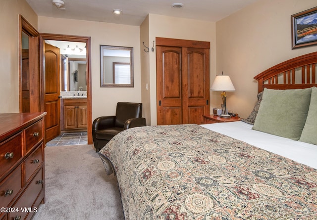 bedroom with light carpet, ensuite bath, and a closet