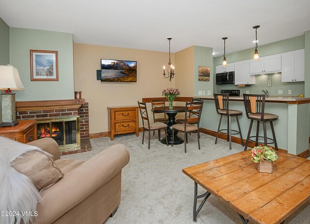 living room with an inviting chandelier, a fireplace, sink, and light carpet