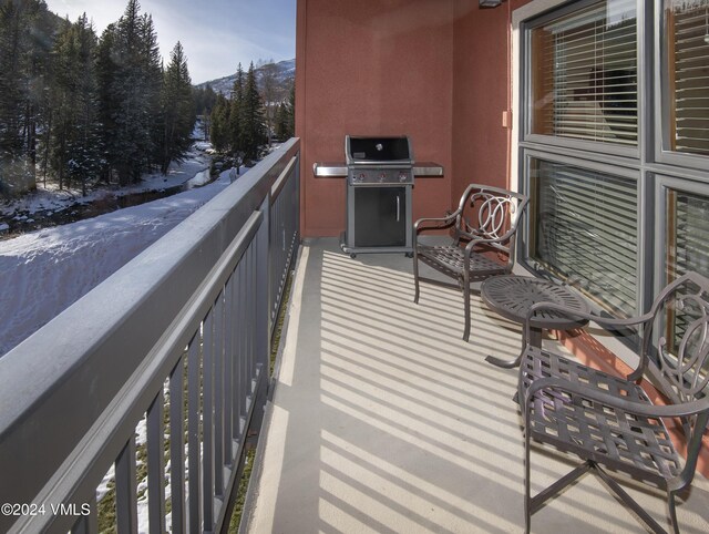 snow covered back of property with a grill