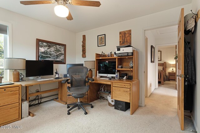 office space with light carpet, ceiling fan, and baseboard heating