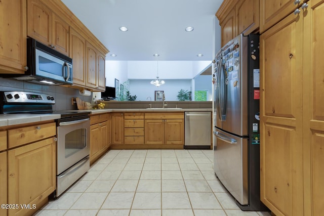 kitchen featuring appliances with stainless steel finishes, tile counters, recessed lighting, light tile patterned floors, and backsplash