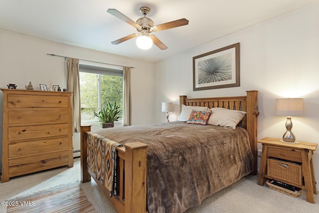 bedroom with light colored carpet, a baseboard radiator, and a ceiling fan