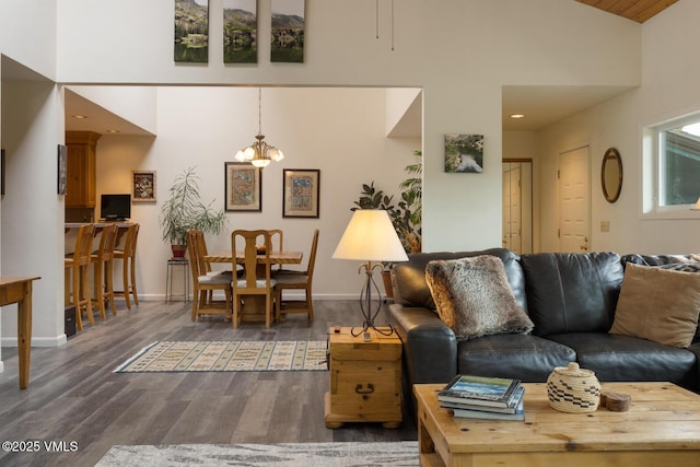 living area featuring high vaulted ceiling, wood finished floors, a chandelier, baseboards, and recessed lighting