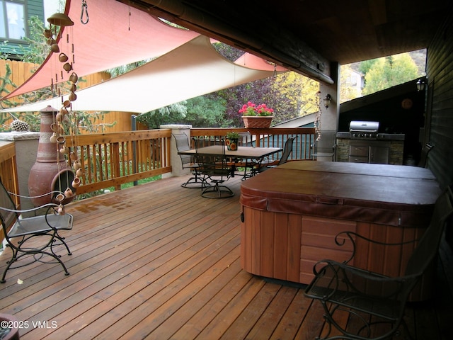 deck featuring a hot tub, outdoor dining area, and area for grilling