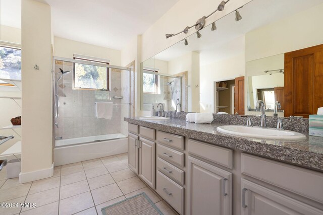 bathroom with tile patterned flooring, vanity, and bath / shower combo with glass door