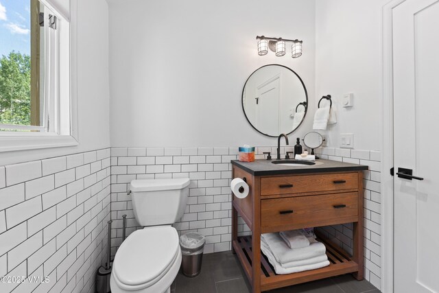 1151 Casolar Del Norte Dr Unit A, Vail, CO 81657 - bathroom featuring tile walls, vanity, a wainscoted wall, and tile patterned floors