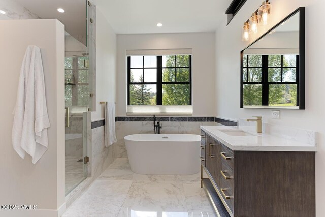 207 Aidan Rd, Eagle, CO 81631 - full bathroom with vanity, a stall shower, marble finish floors, a soaking tub, and wainscoting