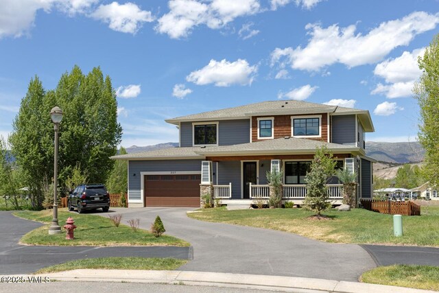 207 Aidan Rd, Eagle, CO 81631 - view of front of home with a porch, asphalt driveway, a front lawn, an attached garage, and a mountain view