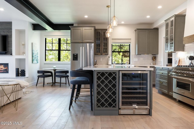 207 Aidan Rd, Eagle, CO 81631 - kitchen featuring wine cooler, appliances with stainless steel finishes, open floor plan, light countertops, and plenty of natural light